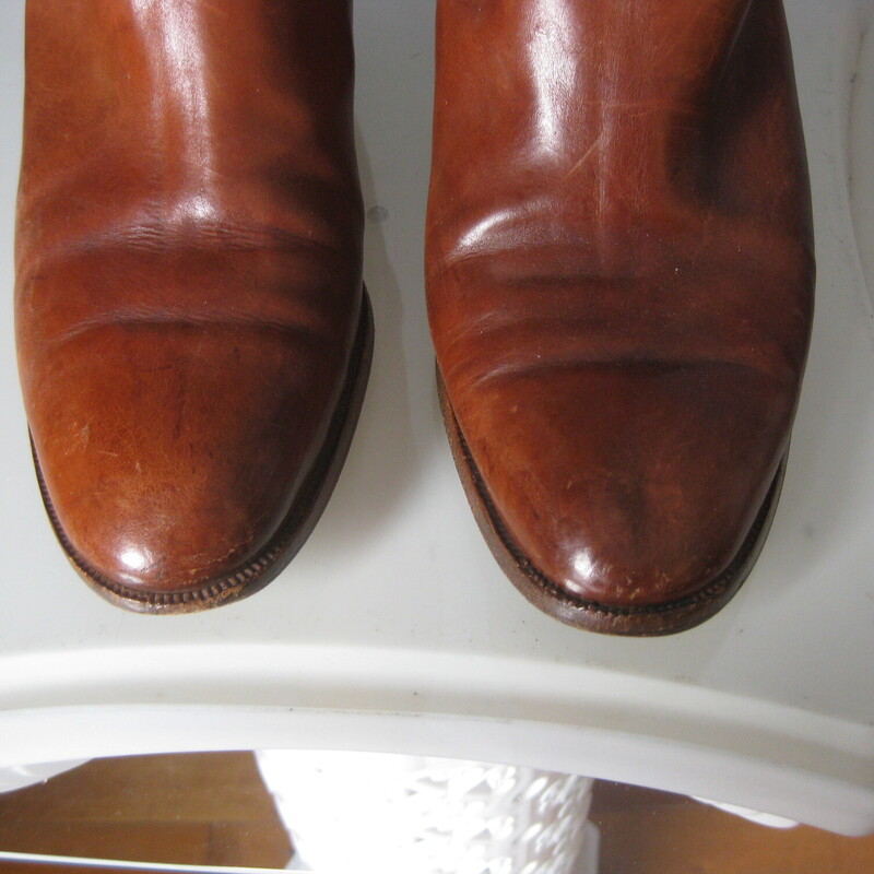 Leather Riding Boots, Brown, Size: 7.5<br />
Beautifully made pair of riding style boots in rich warm tan/brown leather.<br />
These do not have any branding inside or outside.<br />
they have leather outsoles.<br />
They have a thin leather strap detail around the ankles and a low stacked heel.<br />
NO ZIPPERS<br />
Size 7.5<br />
shaft: 15.5  from the top of the arch to the bottom of the heel<br />
width at calf: 6.25<br />
<br />
Good condition, well cared for with signs of use on the toes shaft and bottoms.<br />
Thanks for looking.<br />
#82954