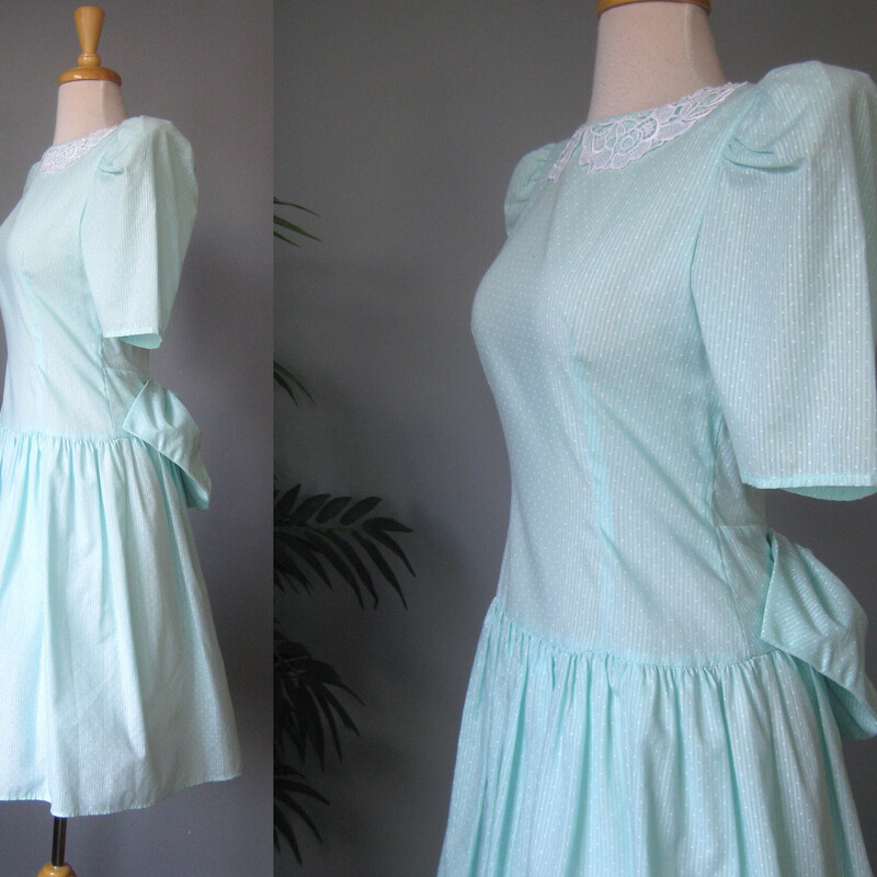 Vtg Polka Dot Lace Collar, Seafoam, Size: XS<br />
Dotted swiss prairie style dress from the early 1980s.<br />
I believe the fabric is cotton but the dress doesn't have any fabric ID tags.<br />
It's lightweight<br />
Green with a lace collar and a BIG bow in the back.<br />
It has a dropped waist and a gathered skirt<br />
It has a built in crinoline that helps pouf out the skirt<br />
VERY big shoulder pads<br />
Short sleeves<br />
no tags<br />
Here are the flat measurements, please double where appropriate:<br />
Shoulder to shoulder: 19.5<br />
Armpit to armpit: 17<br />
Waist: 13.5 - this measurement was taken at the natural waist<br />
Hip: free<br />
Length: 28<br />
excellent condition, it has a small smudge on the front, pls see all the photos.<br />
<br />
Thanks for looking!<br />
#78803