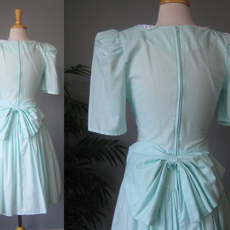 Vtg Polka Dot Lace Collar, Seafoam, Size: XS<br />
Dotted swiss prairie style dress from the early 1980s.<br />
I believe the fabric is cotton but the dress doesn't have any fabric ID tags.<br />
It's lightweight<br />
Green with a lace collar and a BIG bow in the back.<br />
It has a dropped waist and a gathered skirt<br />
It has a built in crinoline that helps pouf out the skirt<br />
VERY big shoulder pads<br />
Short sleeves<br />
no tags<br />
Here are the flat measurements, please double where appropriate:<br />
Shoulder to shoulder: 19.5<br />
Armpit to armpit: 17<br />
Waist: 13.5 - this measurement was taken at the natural waist<br />
Hip: free<br />
Length: 28<br />
excellent condition, it has a small smudge on the front, pls see all the photos.<br />
<br />
Thanks for looking!<br />
#78803