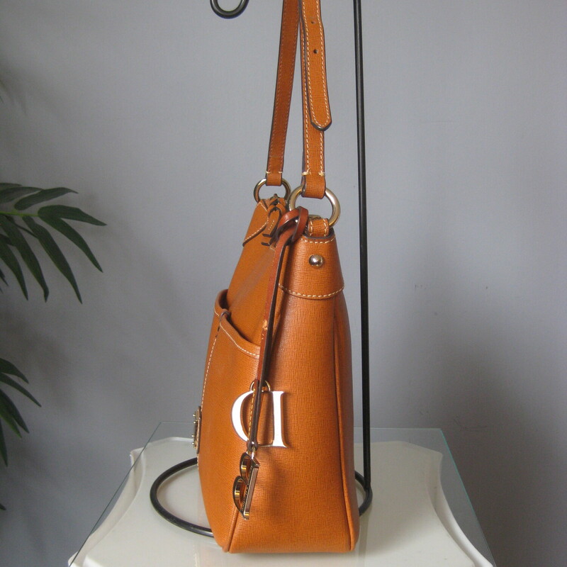 Dooney&Bourke Steffano, Brown, Size: None<br />
Sleek Dooney & Bourke in warm tone tan.<br />
Red lining<br />
Single shoulder strap adjusts from 10 minimum to 14 maximum<br />
the bag is 10.5 x 9 x 3.5<br />
Gold hardware including big bold D & B bag charms<br />
top zipper<br />
2 outside slip pockets on the front<br />
three slip pockets inside, and one zippered pocket inside.<br />
Great condition, a little bit of wear on the thin thongs holding the bag charms.<br />
<br />
Thanks for looking<br />
#82777