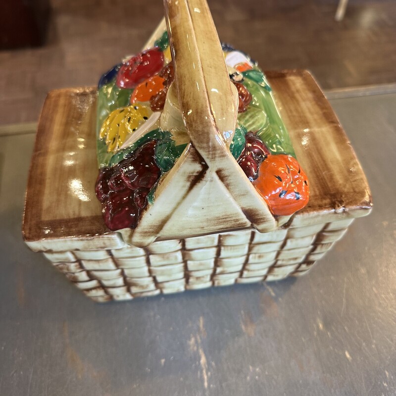 McCoy Fruit Cookie Jar,
Size: 7x5x8
This McCoy cookie jar is in the shape of a picnic basket filled with different fruits.  A baket weave pattern on the base with the handle  of the picnic basket lifting off to grab a cookie.  Made in the USA.  One of a few McCoy pieces that did not have a stamp.