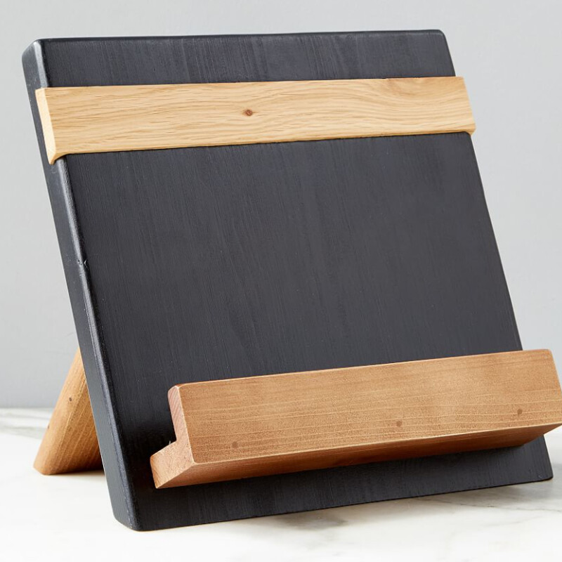 Pottery Barn Reclaimed Wood  Book Holder
Black Tan Oak and Pine Wood
Size: 11x8x10H

A countertop essential for your culinary adventures, these Reclaimed Wood Cookbook Holders are made of eco-friendly materials and finished with a black wax that's 100% plant-based and totally food safe. Boasting a contrasting slat and shelf with lip on the stand’s angled surface, it frees up your hands and ensures your recipes stay within sight.
Retail $150
NEW