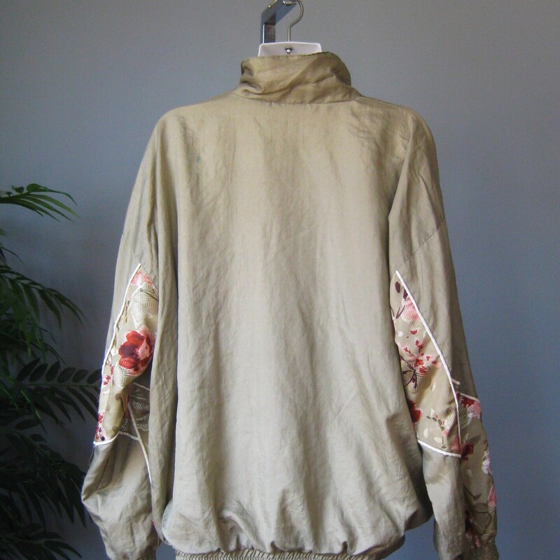 Vtg NOS Nylon Windbreaker, Green, Size: Large<br />
Fun 1980s or 1990s windbreaker track jacket in sage green with pink and white florals<br />
zip front, zip pockets<br />
elasticized cuff and waist with plent of snap<br />
crinkly nylon shell<br />
cotton/poly blend lining<br />
by Lauren Brooke made in Pakistan<br />
New with tags, never worn.<br />
<br />
Marked size Large, fit is supposed to be oversized<br />
flat measurements:<br />
armpit to armpit: 28<br />
width at hem, unstretched: 21<br />
underarm sleeve length: 18<br />
length: 28.5<br />
<br />
thanks for looking!<br />
#81286