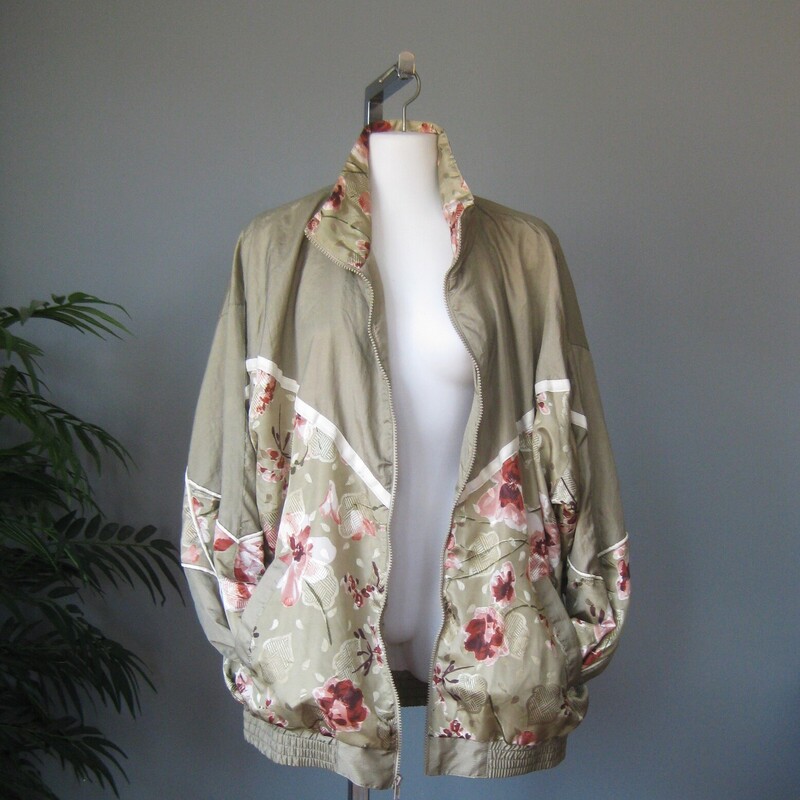 Vtg NOS Nylon Windbreaker, Green, Size: Large<br />
Fun 1980s or 1990s windbreaker track jacket in sage green with pink and white florals<br />
zip front, zip pockets<br />
elasticized cuff and waist with plent of snap<br />
crinkly nylon shell<br />
cotton/poly blend lining<br />
by Lauren Brooke made in Pakistan<br />
New with tags, never worn.<br />
<br />
Marked size Large, fit is supposed to be oversized<br />
flat measurements:<br />
armpit to armpit: 28<br />
width at hem, unstretched: 21<br />
underarm sleeve length: 18<br />
length: 28.5<br />
<br />
thanks for looking!<br />
#81286