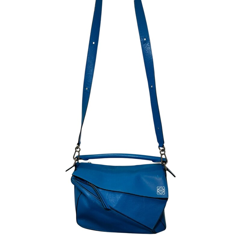 Loewe Puzzle Leather Blue Bag  Crossbody.<br />
<br />
Serial Code:011507<br />
<br />
Dimensions:12 L x 10 H inches<br />
<br />
In fair condition. Scratches and discoloration throughout the leather. Corner wear and interior marks.<br />
<br />
Does not come with original dust bag or box.
