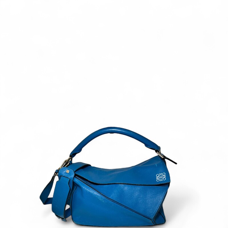 Loewe Puzzle Leather Blue Bag  Crossbody.

Serial Code:011507

Dimensions:12 L x 10 H inches

In fair condition. Scratches and discoloration throughout the leather. Corner wear and interior marks.

Does not come with original dust bag or box.