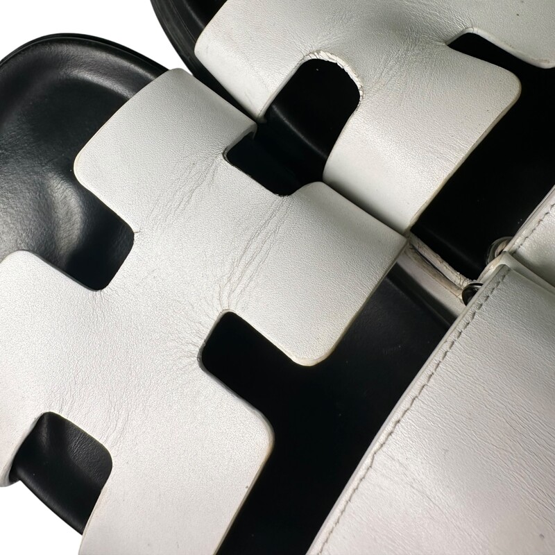 Hermes Chypre Sandals White<br />
<br />
Size: 38<br />
<br />
Code: FR222299Z<br />
<br />
Creasing to the leather. Light staining and scuffing to the interior.<br />
<br />
Does not come with the original dust bag or box.