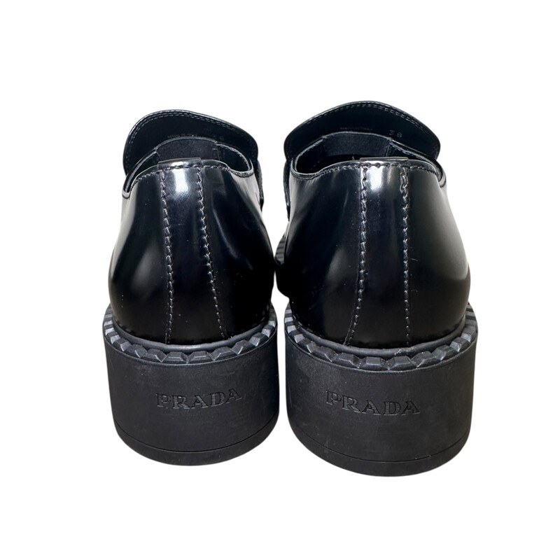 Prada Spazzolato Metal Triangle Black Loafer<br />
<br />
Size 38<br />
<br />
In excellent condition.<br />
<br />
Comes with original box.