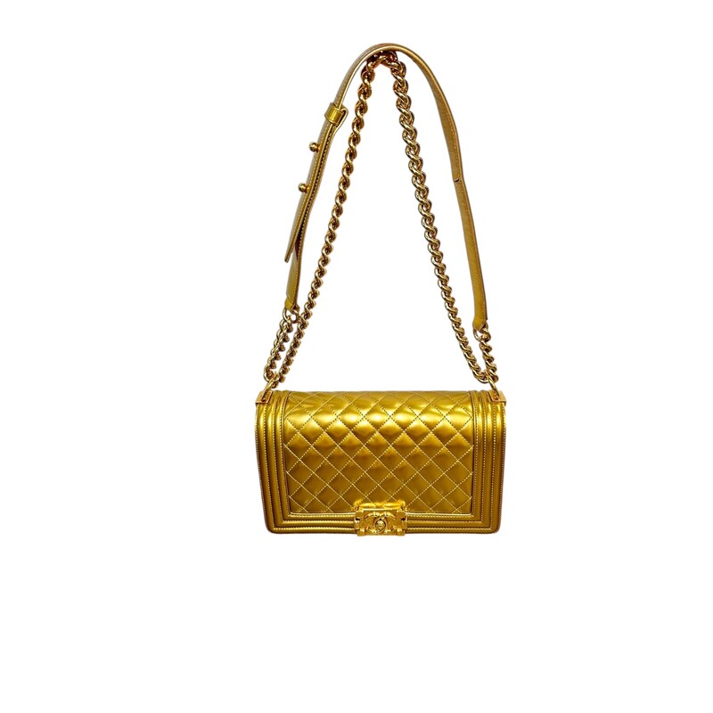 Chanel Boy Patent Gold Medium Handbag<br />
<br />
Date Code: 1973****<br />
<br />
Dimensions:<br />
Length: 9.75 in<br />
Width: 3 in<br />
Height: 5.5 in<br />
Drop: 21 in<br />
Drop: 12 in<br />
<br />
In very good condition. Light scuffsing to the hardware and corners of handbag. Crack on the inside of the strap and leather torn. Strap is still in working condition.<br />
<br />
Does not come with the original dust bag or box.