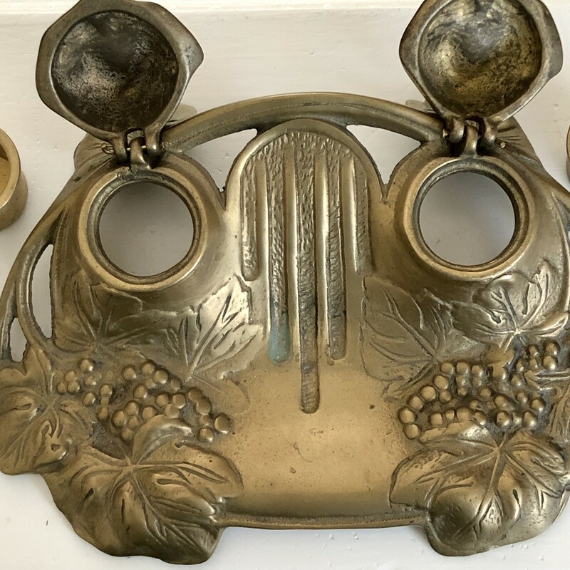 French Art Nouveau Brass Double Ink Well. Features a grape wreath design and has two removable brass ink holders. 7in W X 4in D X 2.5in H.