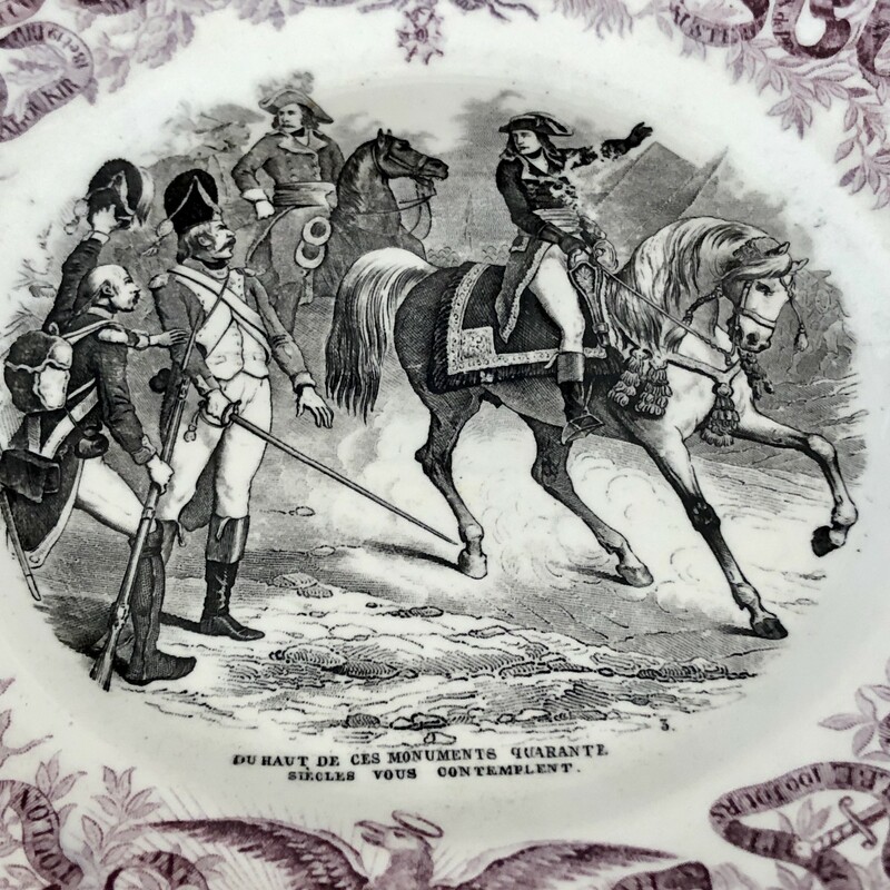 French Napoleon Commerative Assiettes Parlantes Plate. c.1840s Due Haut de Ces Monuments Qurante Siecles vous Contemplent<br />
Assiettes Parlantes, or talking plates, are French transferware plates with sayings on them. The most collectible illustrate the life of a French hero such as the plates depicting Napoleon. Really unusual to find in purple. 8