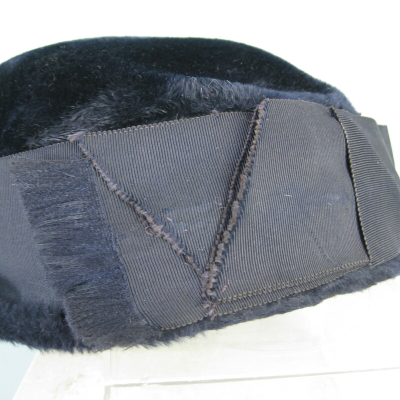 Simple winter hat in very dark navy blue fur velour from the 1950s
It's basically a pillbox with a teeny brim and a wide folded grosgrain ribbon around the crown.
The ribbon forms a tailored flat bow with frayed edges.

Stamped  Ballet
Made in Czechoslovakia

Great condition, except for the ribbon being slightly discolored at the back.
Inner hat band measures: 21 1/4

Thanks for looking.
#31262
