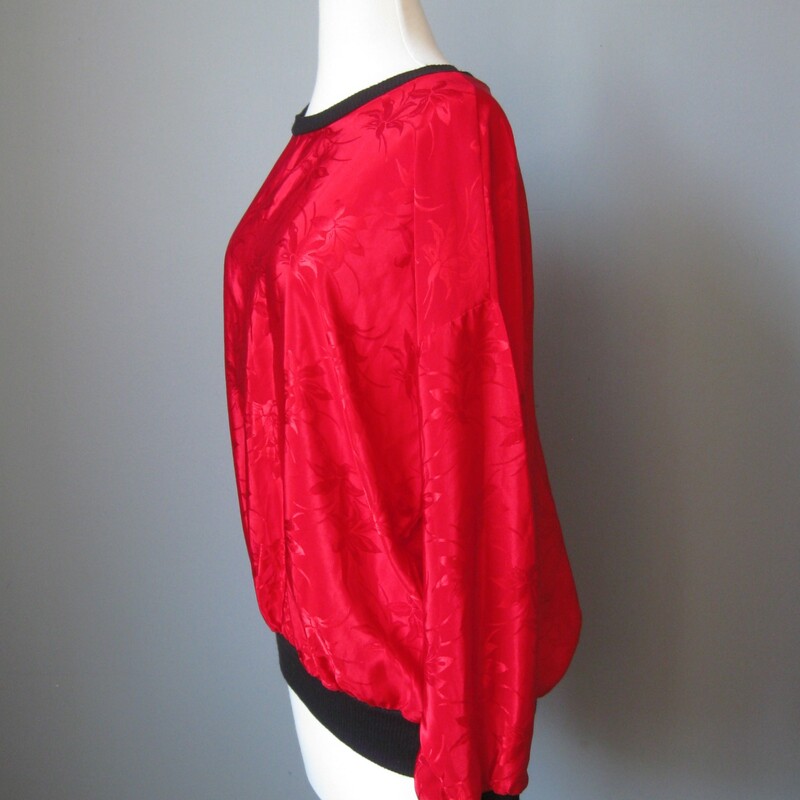 Bright red shirt from the 1980s in satin jacquard<br />
<br />
Black contrast trim at neck and sleeve ends<br />
<br />
Made in the USA by the brand Claudia<br />
Marked size large<br />
flat measurements:<br />
armpit to armpit: 24in<br />
length: 24 3/4in<br />
<br />
excellent condition, no flaws<br />
<br />
thanks for looking!