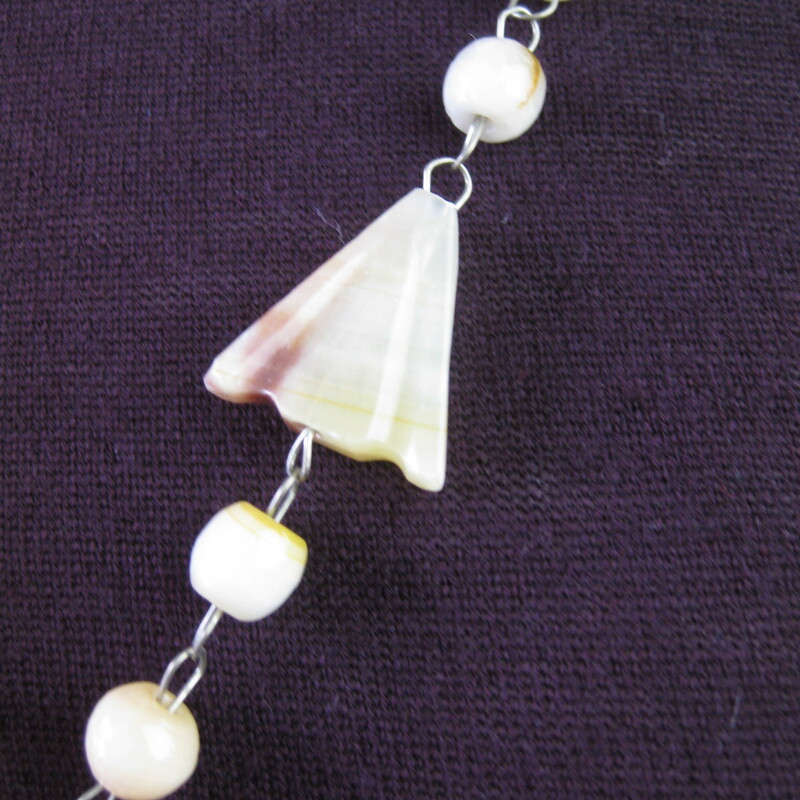 Pendant necklace made of pale ivory round and arrow shaped stone beads on a thin metal wire.<br />
Large teardrop pendant of carved stone.<br />
The carving is a Sun God or sunburst design<br />
<br />
<br />
simple hook clasp.<br />
<br />
Necklace: 27in long<br />
Pendant: 2. 1/2in x 1 3/4in<br />
<br />
Thanks for looking!