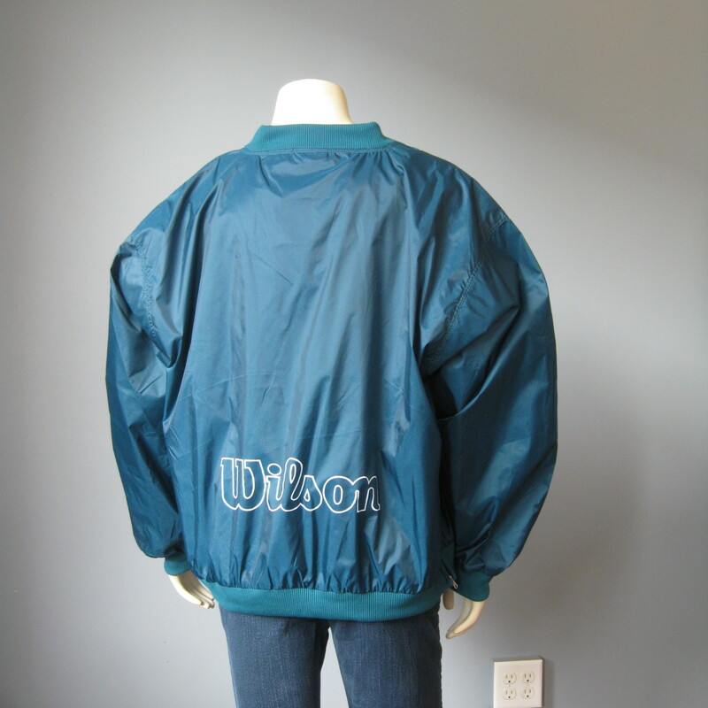 Never worn , still has the tags on.
Country Club type nylon pullover windbreaker from
Wilson's

Please note this item is TEAL GREEN not turquoise blue as it appears in the photos - second photo is edited to get it closer to the actual color.
Sweater Cuffs, neck and waist
Venting zipper on one side
100% Nylon shell
100% Cotton feel poly lining
Marked Size XL
Flat measurements:
armpit to armpit; 28 1/2in
width at hem: 22in
length: 27 1/2in

Perfect brand new condition.

Thanks for looking!