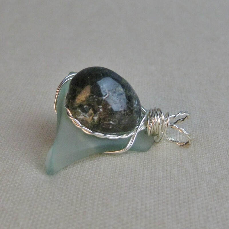Perfect condition<br />
Wire-wrapped stone and glass. Stone is polished but has some natural pitted areas that didn't get ground down enough. Wire is silver-toned.<br />
I like that it has two 'bales', this gives the pendant a more solid and stable look and feel on your chain.<br />
Pedant is 1 1/2in by 1 1/4in<br />
Thanks for looking!