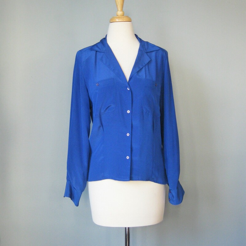 Simple blue blouse from the 1980s<br />
Shoulder pads, washed silk look and feel - but it's 100% polyester<br />
Open v neck, long sleeves<br />
by Marlis<br />
flat measurements:<br />
shoulder to shoulder: 15in<br />
armpit to armpit: 20in<br />
underarm sleeve seam length: 17in<br />
length: 24in<br />
<br />
thanks for looking!<br />
#14556