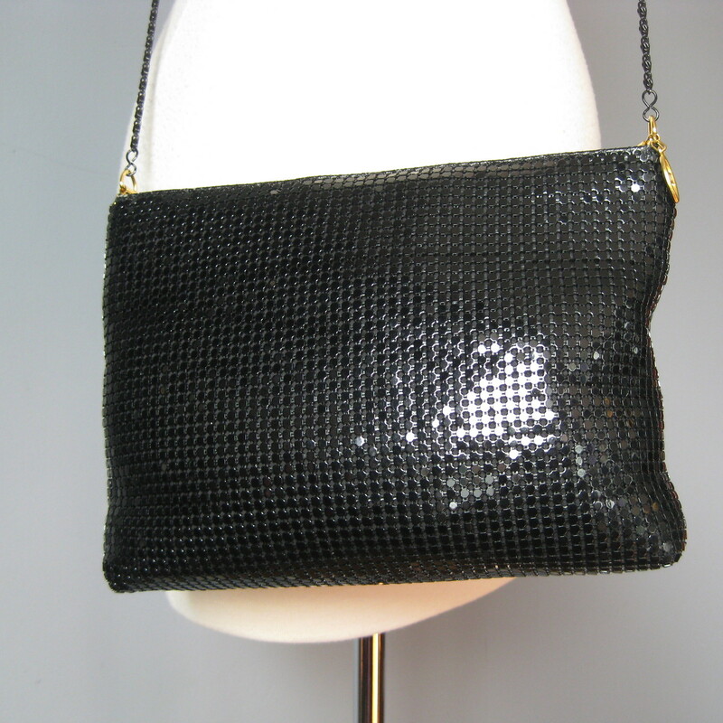 Cool black metal mesh evening bag with a thin black chain strap.<br />
Top Zipper<br />
Just in case the shiny mesh doesn't catch enough light, there is a free swinging swag of mesh at the front poking through a gold ring.<br />
Slim but flexible, will hold everything you need<br />
No tags<br />
I slip pocket inside<br />
Tiny bit of wear on the top edge<br />
10.5in x 7in x 2in<br />
chain drop: 22in<br />
<br />
Thanks for looking!<br />
#15167