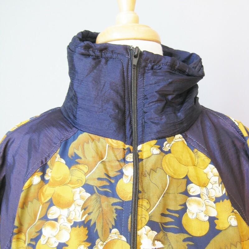 Navy Blue & gold fall floral print bomber jacket from the 1980s by Great Gear Clothing Co.<br />
High funnel neck<br />
elasticized waist and cuffs<br />
Shell is 100% nylon<br />
Fully lined in poly cotton blend<br />
Shoulder pads<br />
zipper Pockets<br />
Drawstring hip<br />
made in Pakistan<br />
Markeed size small but should fit almost anyone!<br />
flat measurements:<br />
armpit to armpit: 24in<br />
length: 26in<br />
shoulder to shoulder: 17in<br />
thanks for looking!<br />
#14550