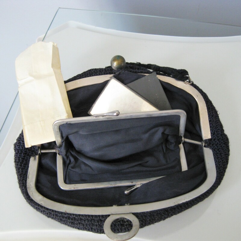 Old Old purse with a no nonsense brass/steel hinged frame and ball shaped tilt clasp<br />
Black<br />
Lined<br />
Opens up wide<br />
Inside you find a kisslock pocket and a little mirror, still wrapped in its orginal paper<br />
Decent sized, should fit all the essentials for an evening out.<br />
<br />
Excellent vintage condition. The handle feels a little thin, sound but won't tolerate a ton of stress<br />
<br />
Width 8.5in<br />
height: 5in<br />
Handle drop: 3.5in<br />
<br />
Thanks for looking!<br />
#14011