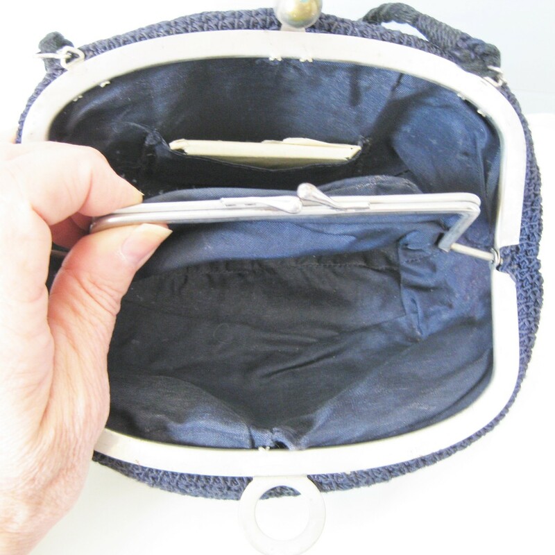 Old Old purse with a no nonsense brass/steel hinged frame and ball shaped tilt clasp<br />
Black<br />
Lined<br />
Opens up wide<br />
Inside you find a kisslock pocket and a little mirror, still wrapped in its orginal paper<br />
Decent sized, should fit all the essentials for an evening out.<br />
<br />
Excellent vintage condition. The handle feels a little thin, sound but won't tolerate a ton of stress<br />
<br />
Width 8.5in<br />
height: 5in<br />
Handle drop: 3.5in<br />
<br />
Thanks for looking!<br />
#14011