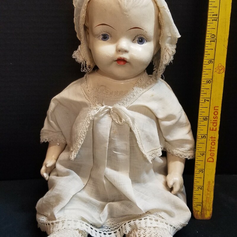 Bisque and cloth doll<br />
movable arms and legs<br />
crochet booties; linen clothing and bonnet<br />
13 in seated