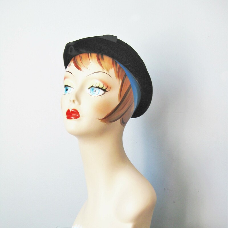 Here's a cute and saucy little bowler in black velour with a gros grain ribbon and a matte black faceted oblong 'jewel' at the front.

The hat has a small turned-up brim.

Excellent condition

Inner hat band: 20in, you'll probably need a pin to keep this on.

Thanks for looking!
#22060