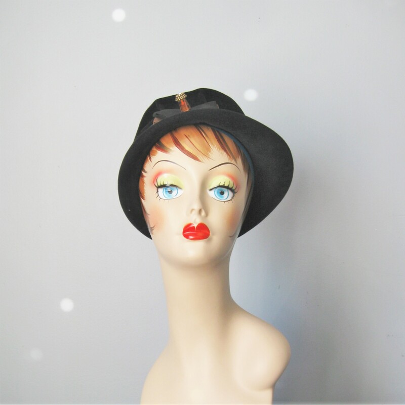 This simple tall crowned black hat is made of felt. It has an absolutely amazing lucite decoration on a wide gros grain ribbon.
Excellent condition.
Small size : Inner hat band measures 21in around

thanks for looking1
#10801