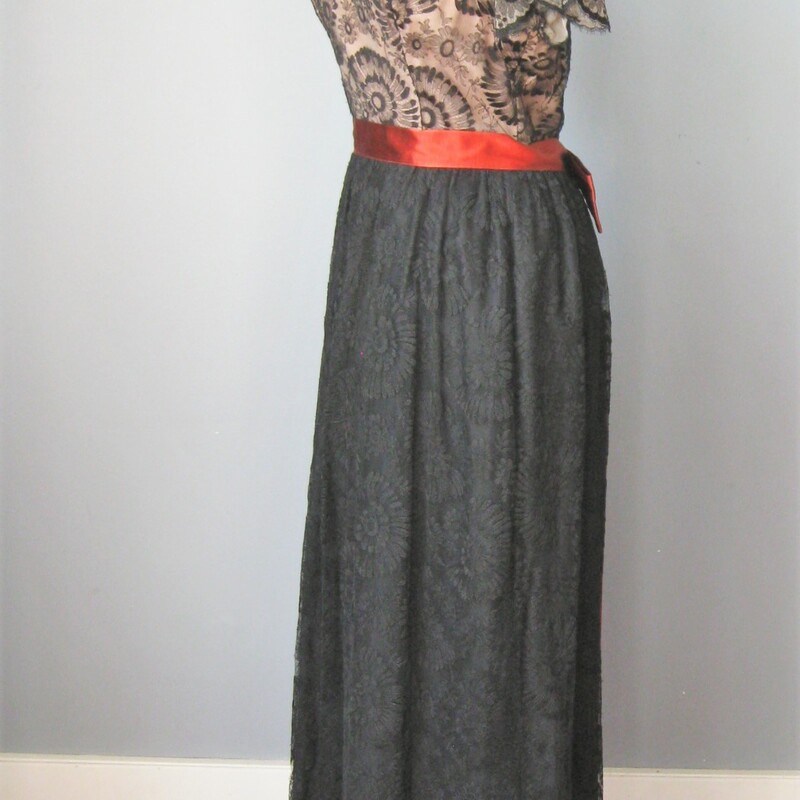 Beautiful black lace gown from the 1960s
by August de Lorenzo for Lee Claire
Bodice is sheer lace w a flesh toned liner
Skirt is fully lined
Waist has a rust colored satin ribbon ending in very long fringed tails at the back
Excellent condition, w a repair to tear in the lace on the skirt
No size tag, please use these flat measurements below to determine if it will fit you.
Should fit about a size 6 person, but def check the measurements
Armpit to armpit: 18.25in
waist: 15in
hip: 25in
length: 54in