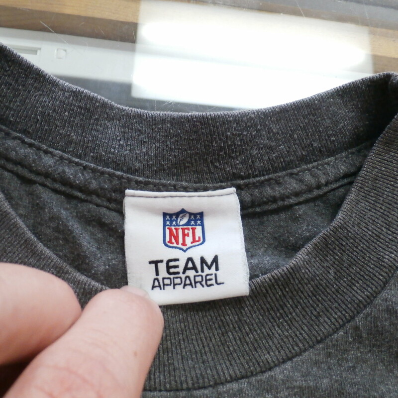Pittsburgh Steelers Team Apparel Adult Shirt Missing Tag Gray #25323<br />
Rating:   (see below) 3 - Good Condition<br />
Team: Pittsburgh Steelers<br />
Player: n/a<br />
Brand: Team Apparel<br />
Size: Missing Tag  - Adult(Measured Flat: Across chest 19\", length 27\")<br />
Measured flat: armpit to armpit; top of shoulder to the hem<br />
Color: Gray<br />
Style: Short sleeve screen pressed shirt<br />
Material: missing tag<br />
Condition: 3 - Good Condition - wrinkled; faded and discolored; pilling and fuzz; feels coarse; logo looks great; missing material and size tag; no stains rips or holes<br />
Item #: 25323<br />
Shipping: FREE