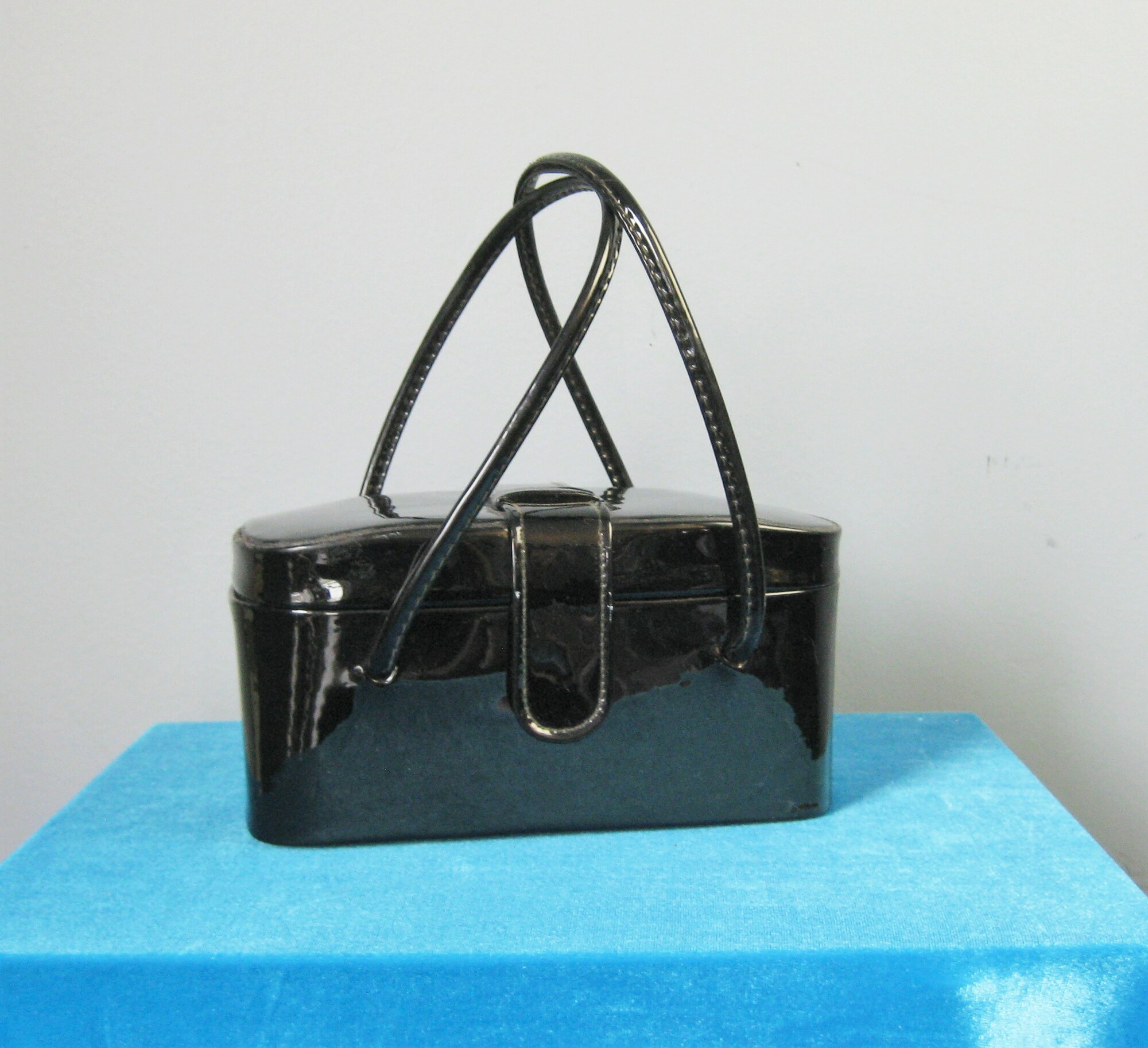Cute little purse in black patent leather with a hinged top and a mirror inside and brass feet
Double handles
Snap closure
Width: 8
Height: 4
Handle Drop: 5.5
Depth: 4.5

Great condition with a melted  (?) round spot on the bottom and the mirror is tarnished.

thanks for looking!
#42800