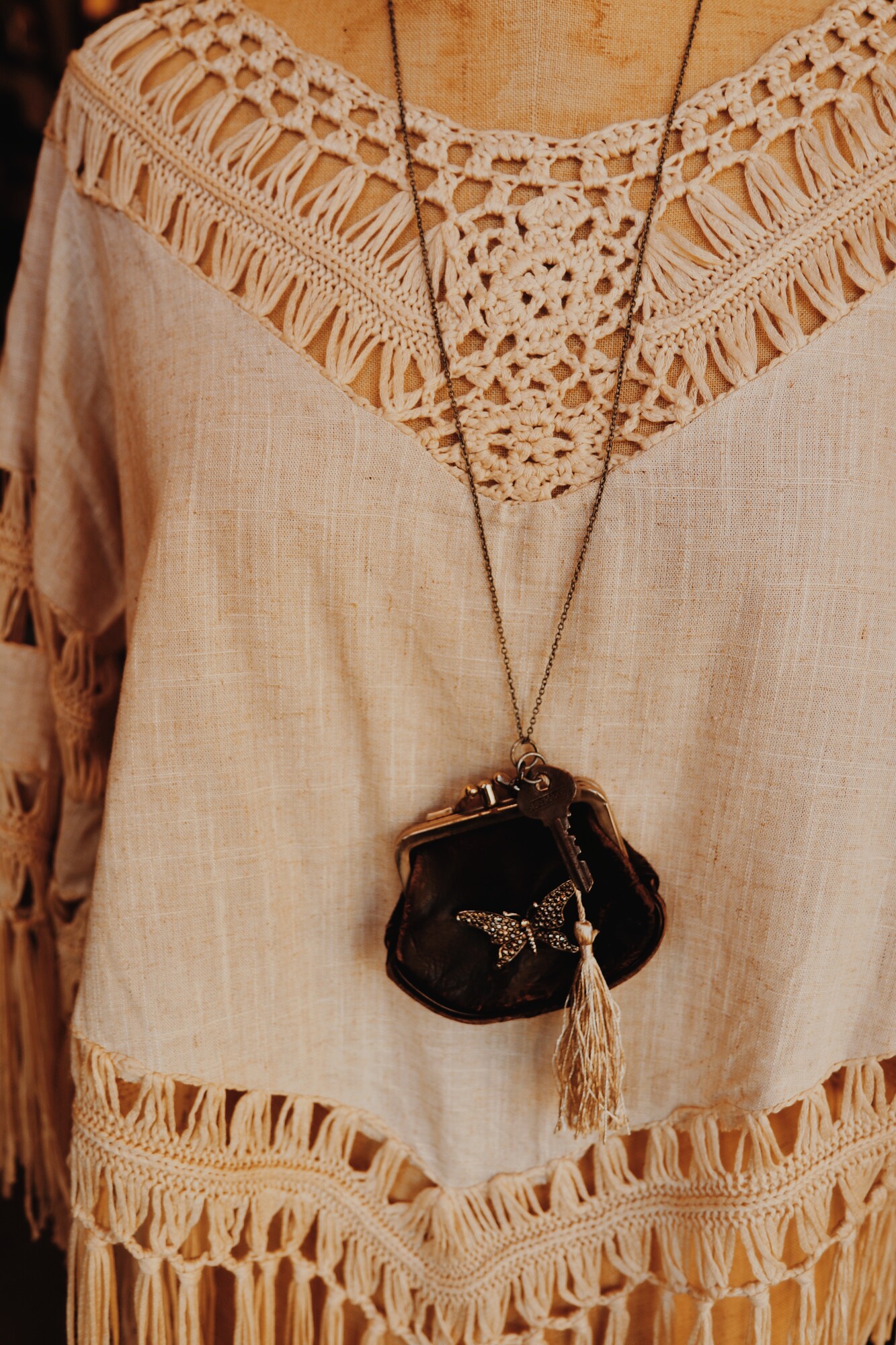 This hand crafted necklace was made from a vintage coin purse and hangs on a 32 inch chain. As well as the coin purse, there is a key and silver tassle.