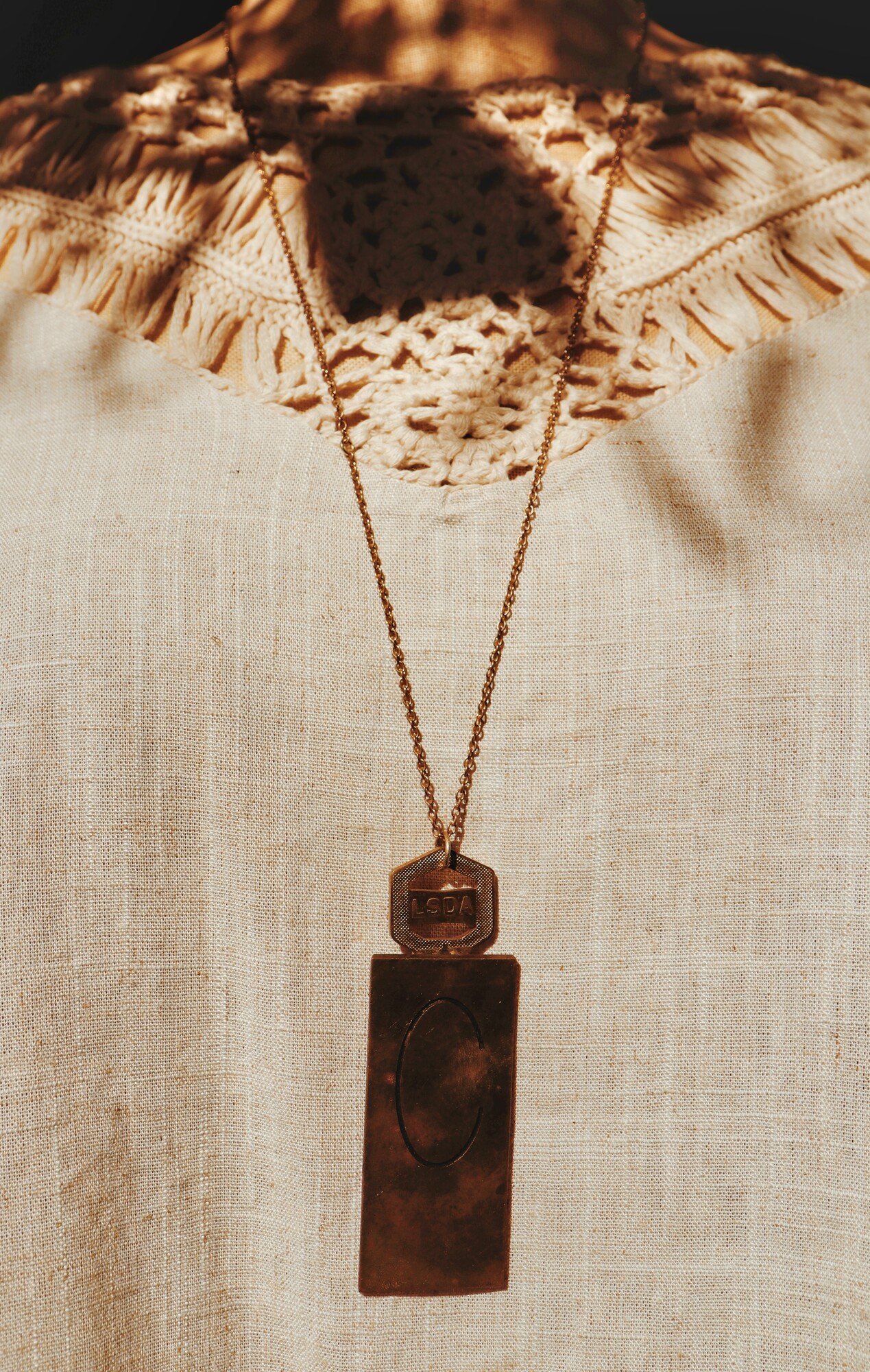 This unique necklace has a C engraved brass plate and hangs from a 30 inch chian!