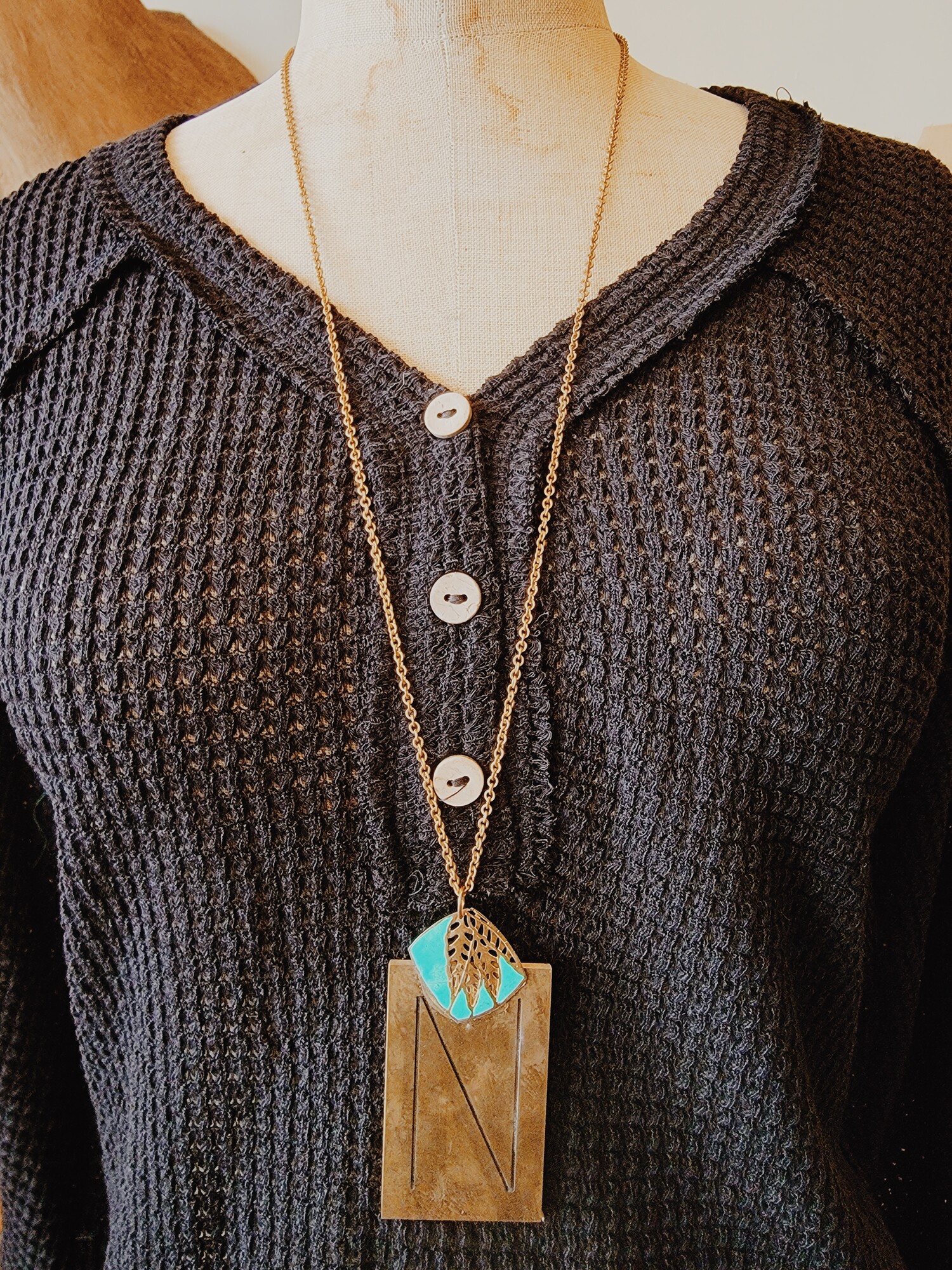 This lovely necklace has an N engraved brass plate and a touch of turquoise! It is on a 32 inch chain.