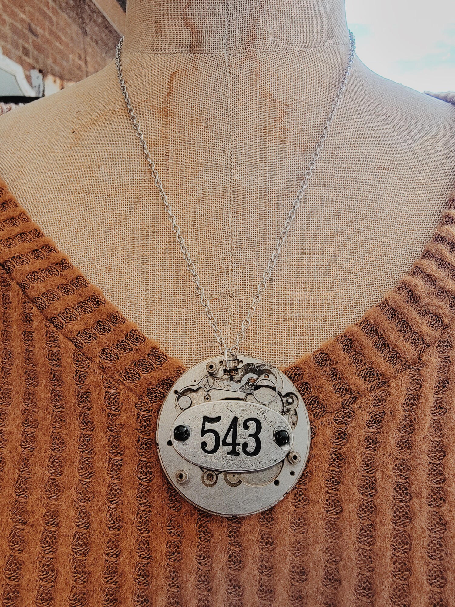 - Hand crafted necklace
- 22 Inch chain
- Clockwork pendant with 543 on the front