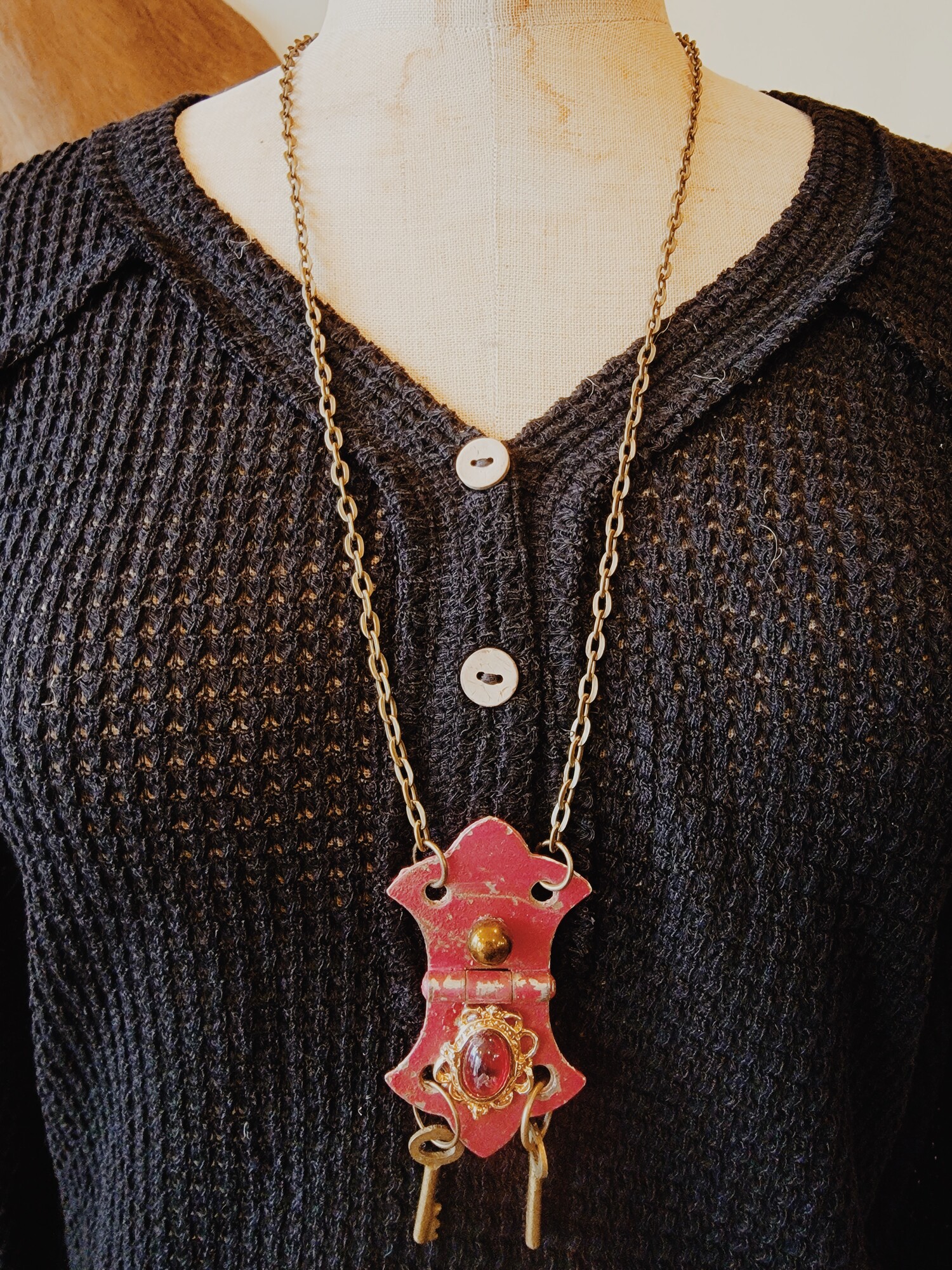 This lovely, hand crafted necklace is on a 29 inch chain and has an adorable red hinge as its pendant with a red stone in the center!