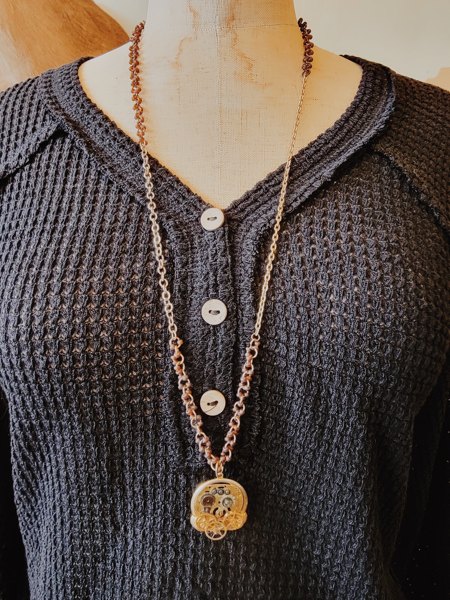 This adorable necklace is on a 32 inch chain with beads strung along portions. Its pendant is a collage of watch parts and faces!