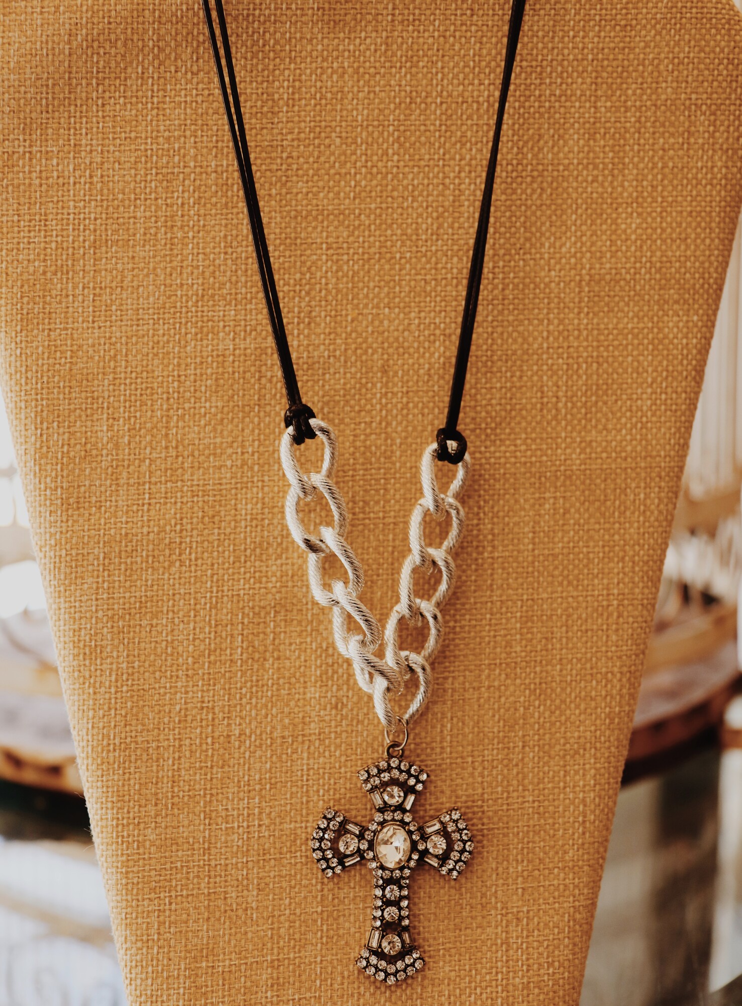 This necklace from Kelli Hawk Designs was handmade with love! It is on a 20 inch chain made of black cording and chunky silver chain and has a rhinestoned cross pendant.