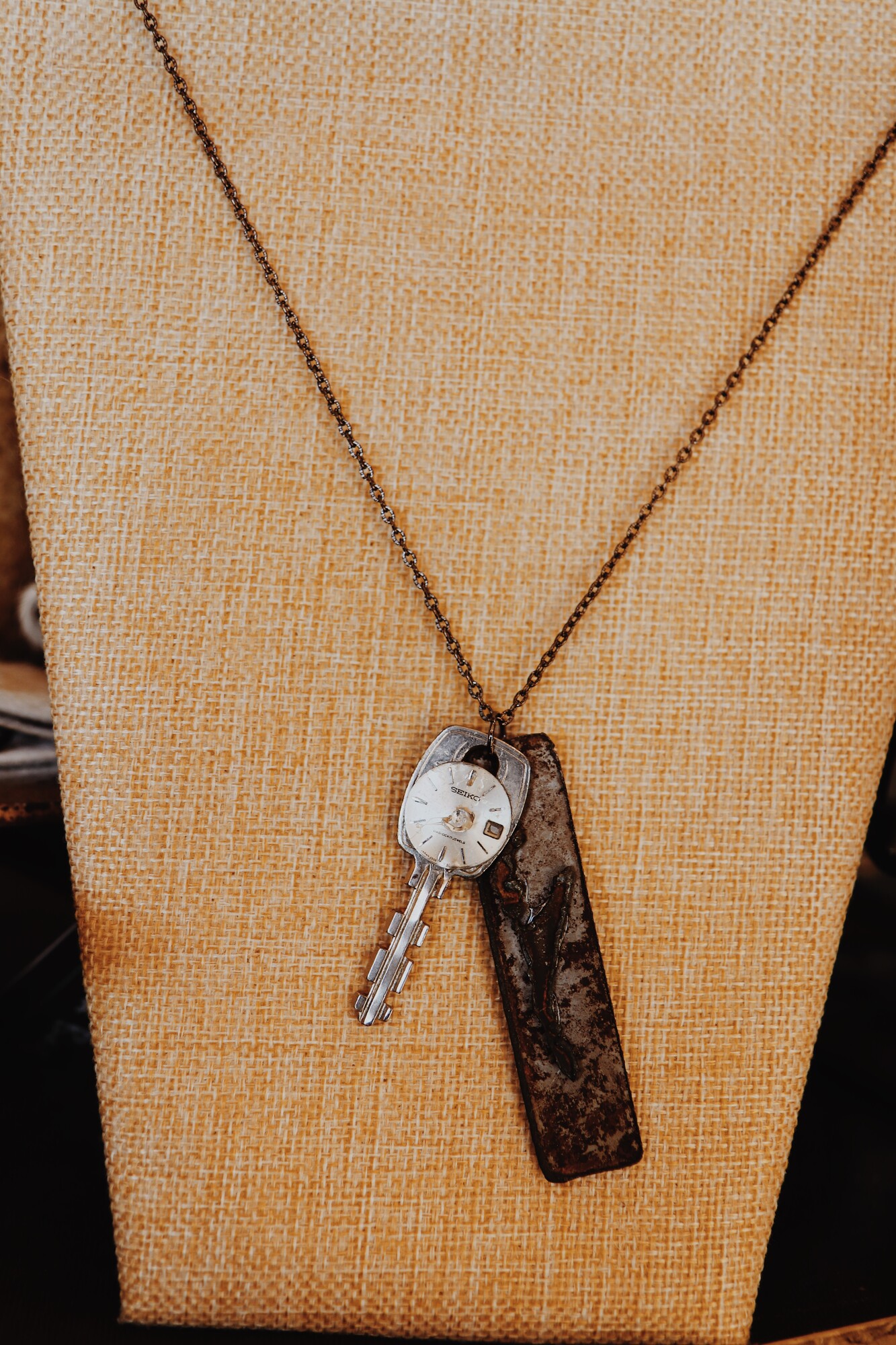This necklace from Kelli Hawk Designs was handmade from vintage pieces! The centerpiece features two vintage metal pieces, one of which is an old key with a watch face attached. This hangs on a 23 inch chain.
