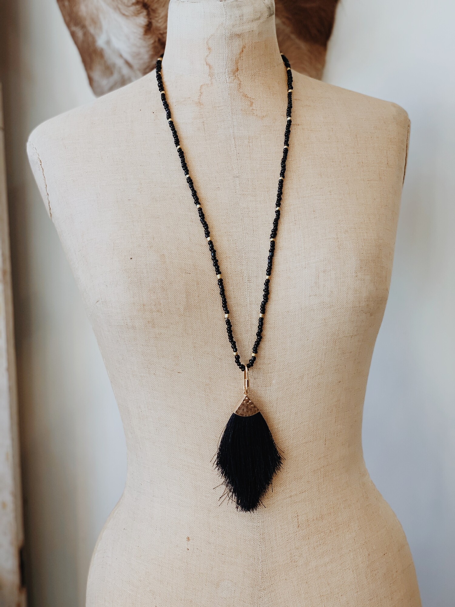 This black tassel necklace is on a 32 inch beaded cord. This beautiful necklace is black with gold accents!