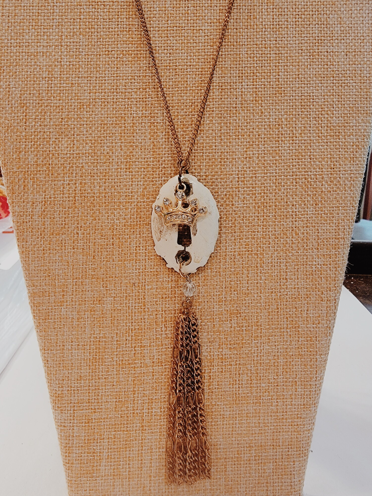 This adorable Kelli Hawk Designs necklace is on a 25 inch chain with a 2 inch extender and has a vintage keyhole as the pendant. The gold crown and gold chain tassel are so unique and perfect for a one of a kind look!