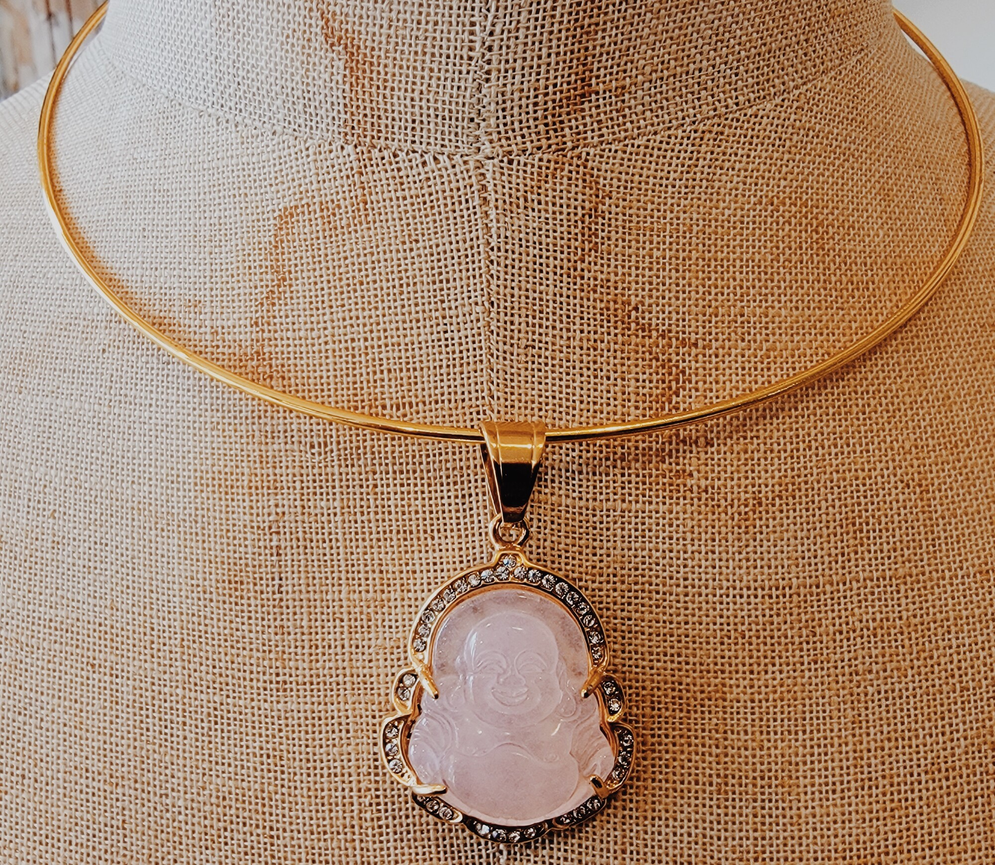 This beautiful gold choker has a pink buddah hanging with a gold border. Such a cute piece for layering!