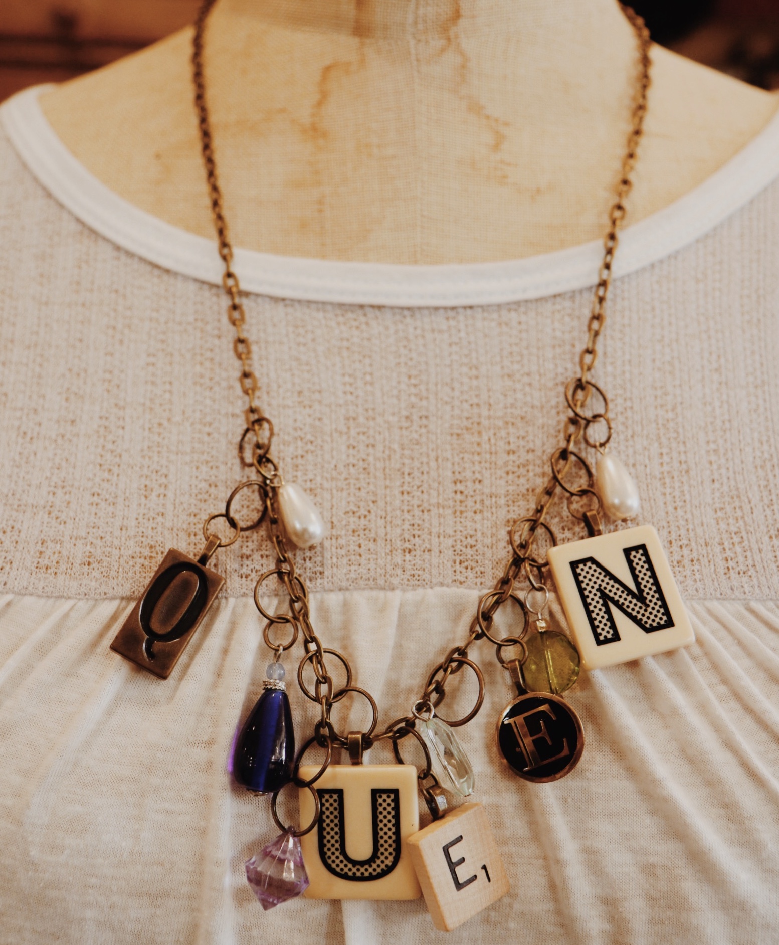 This handmade necklace spells out queen in game pieces and is on a 26 inch chain!