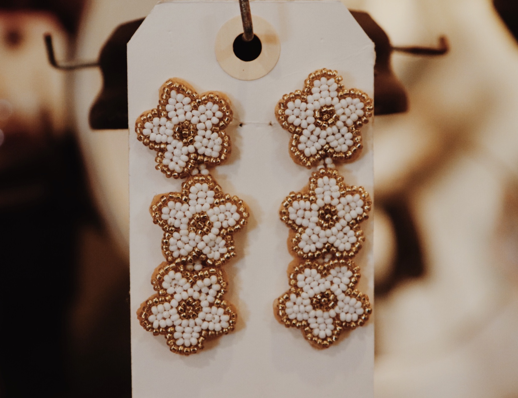 Beaded Flower Earrings, these earrings are composed of white and gold beaded daisies that dangle from one another. Measuring 2.75 inches long.