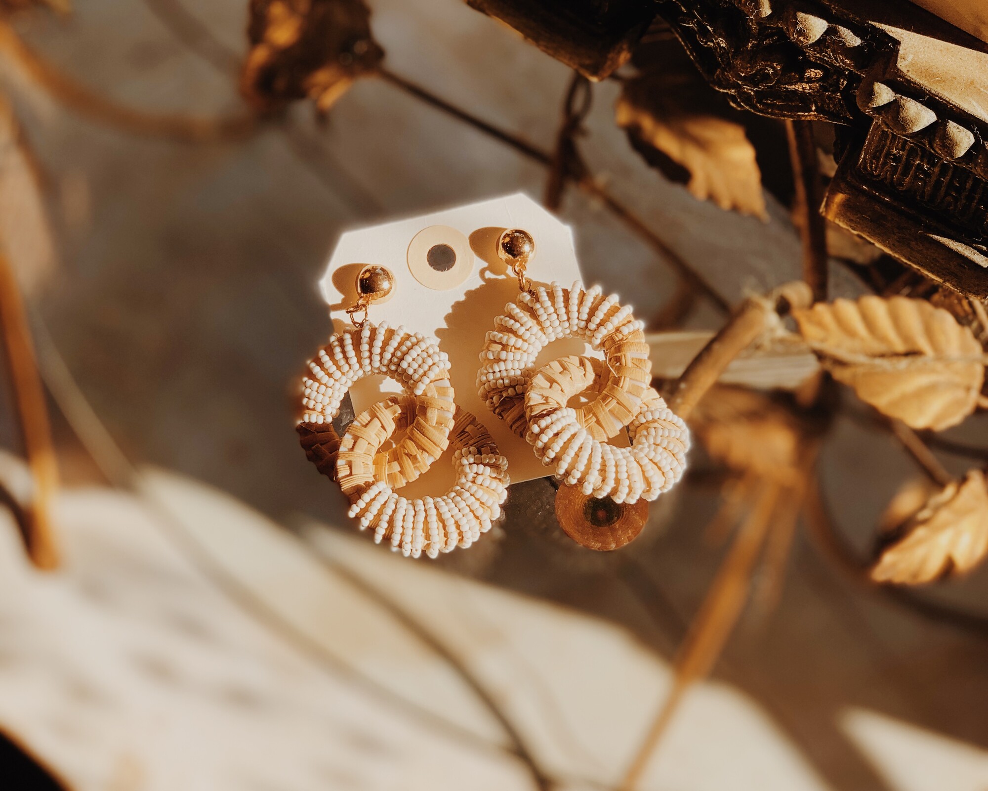 These adorable earrings are made from wicker and have white beads adorning them! They measure 3 inches long.