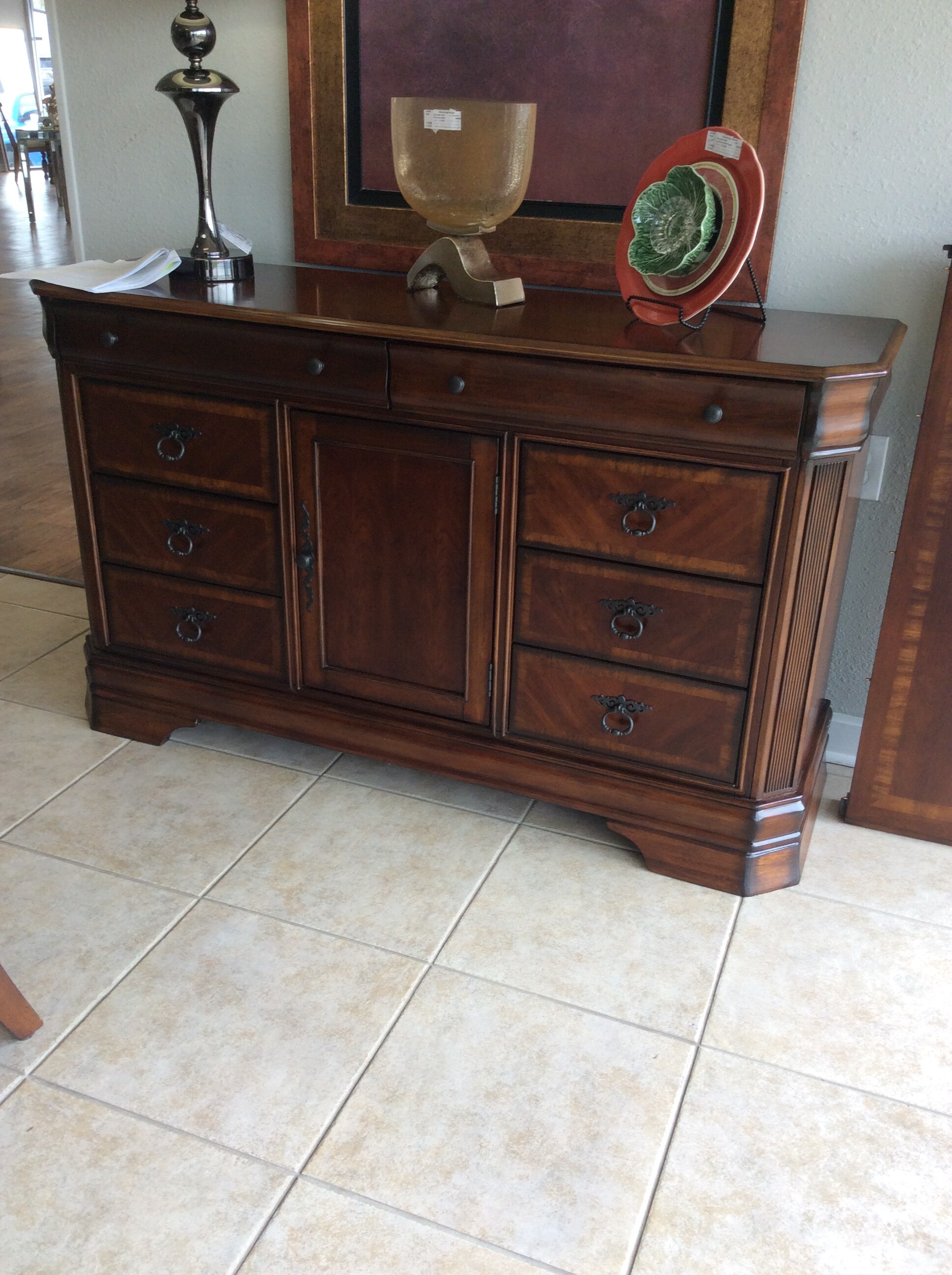 This is a traditional style buffet from Ashley Furniture. It has a cherry finish and beautiful inlaid vaneer details.