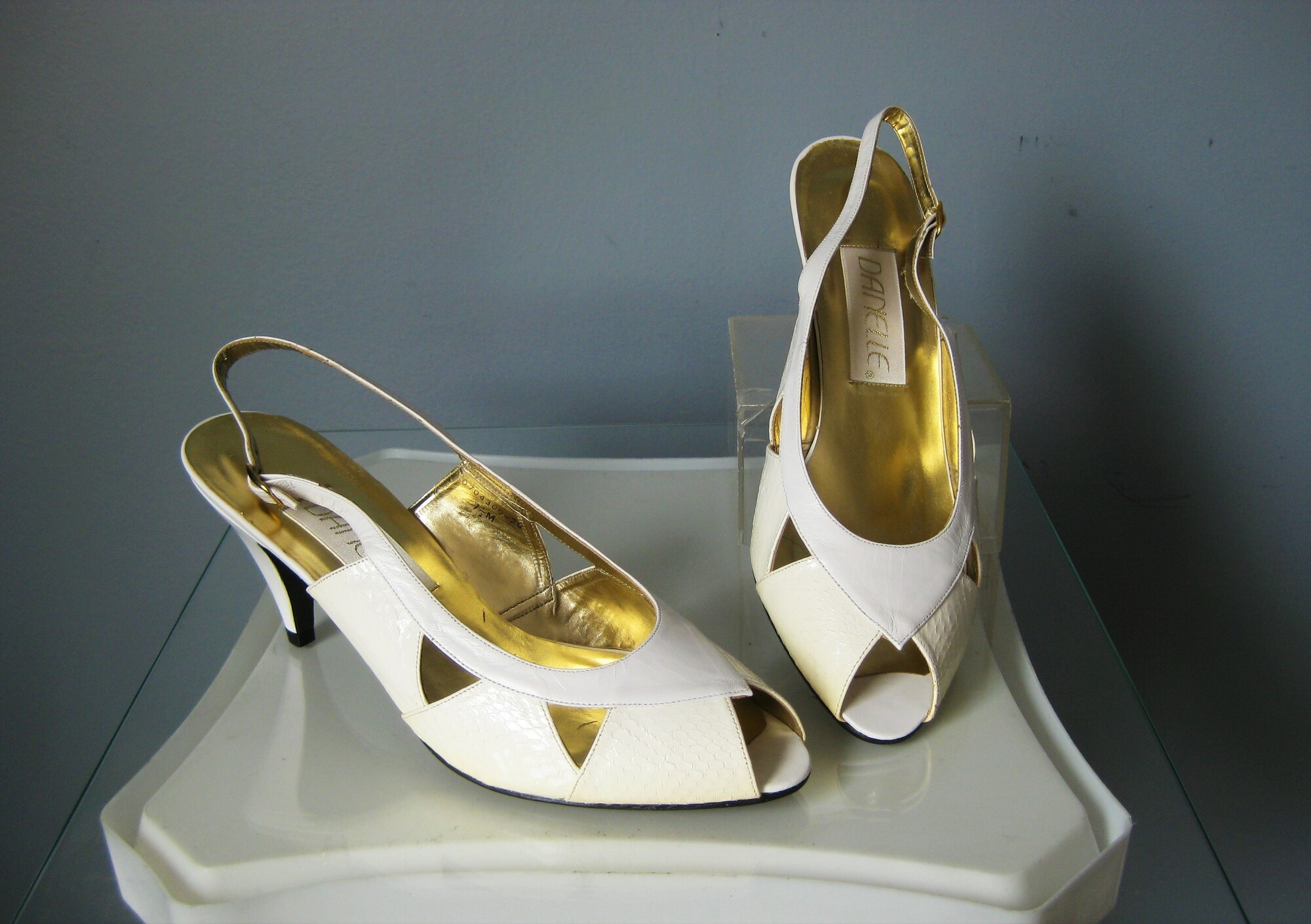 Chic snakeskin slingback pumps from the late 80s or early 90s by Danielle. These are their Beth model.
Ivory in color with bright gold interior.
triangular cutouts
Never worn.
Size 7.5

3 heel

Thank you for looking!
#47167
