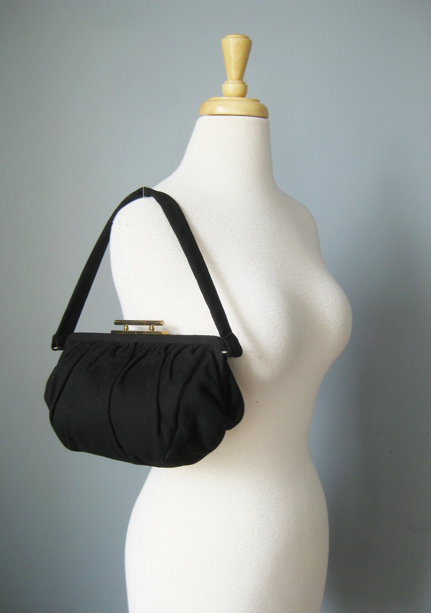 Matte Black, squashy woollen bag with a goldm etal frame and a tilt clasp. It's kind of girly and witchy at the same time.
No Tags
Satin lining
Metal zipper pocket
Excellent condition.
Width: 10
Height: 7
Depth: 3
Handle drop: 7 1/4

Thanks for looking!
#43470