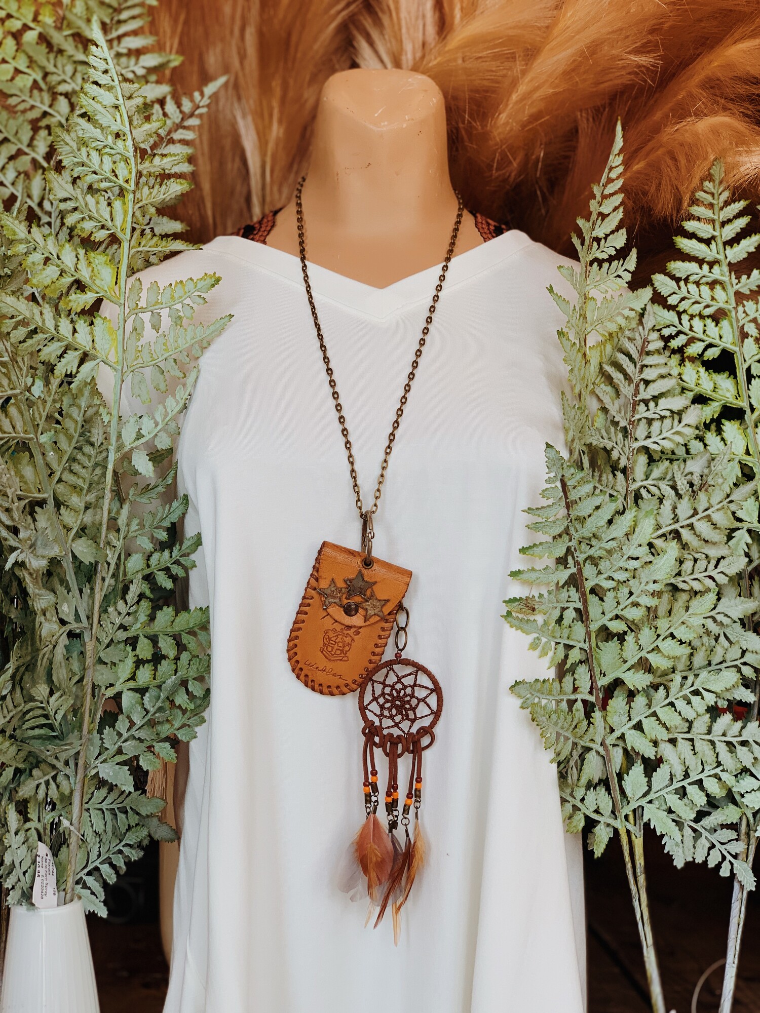 This one of a kind, handmade necklace is on a 28 inch chain and has a leather pouch as the pendant with a feather dream catcher hanging from it!