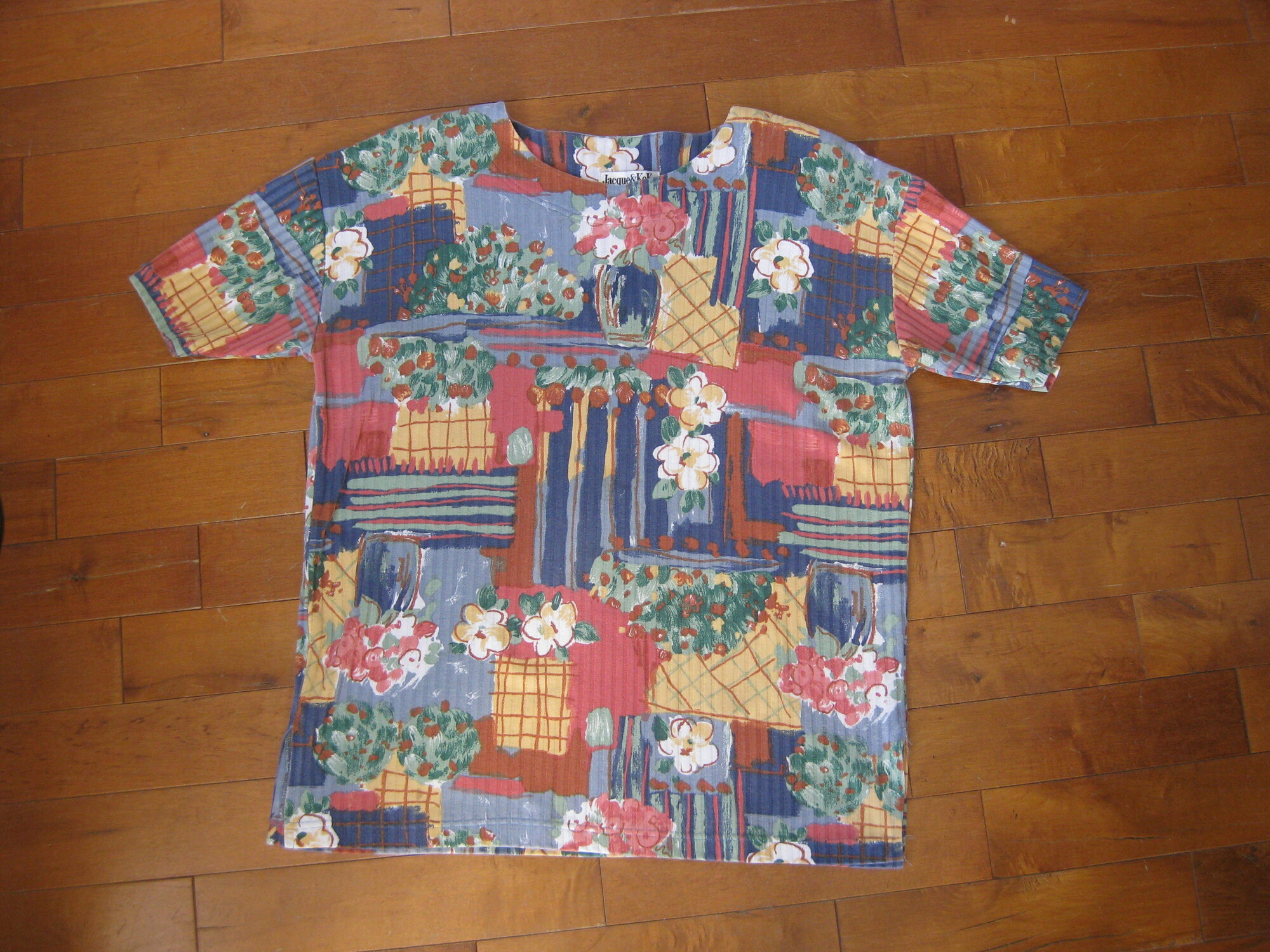 Pretty top in a painterly abstract gardeny print
Mainly blues and oranges
It's a bit long and has slits on the sides so it would look good worn untucked.
Short Sleeves
the fabric is ribbed, substantial  50/50 cotton poly blend.
Shoulder pads

It's by Jacque & Koko and was made in the USA

Flat Measurements please double where appropriate:
Shoulder to shoulder: 18 the shoulder seam is dropped, the 18 is the measurement from the outer edge of each shoulder pad, but the actually shoulder seam is a couple of inches below that.
Armpit to Armpit: 24
length: 27.75
width at hem: 24.5

Pefect condition!
Thanks for looking.
#41804